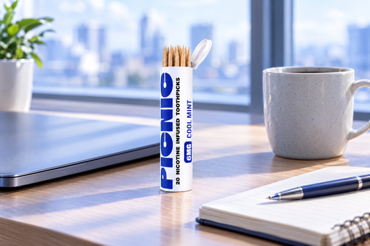 A Picnic Cool Mint 6mg nicotine toothpick tube on an office desk beside a laptop and coffee