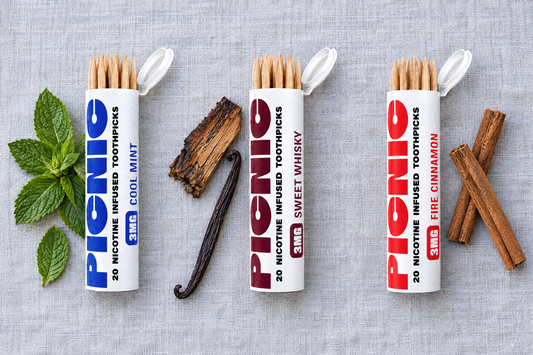 Picnic Cool Mint, Sweet Whiskey and Fire Cinnamon tubes laid out with mint leaves, oak and cinnamon sticks