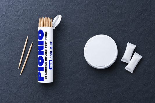 A Picnic nicotine toothpick tube beside a plain nicotine pouch tin, side by side on slate