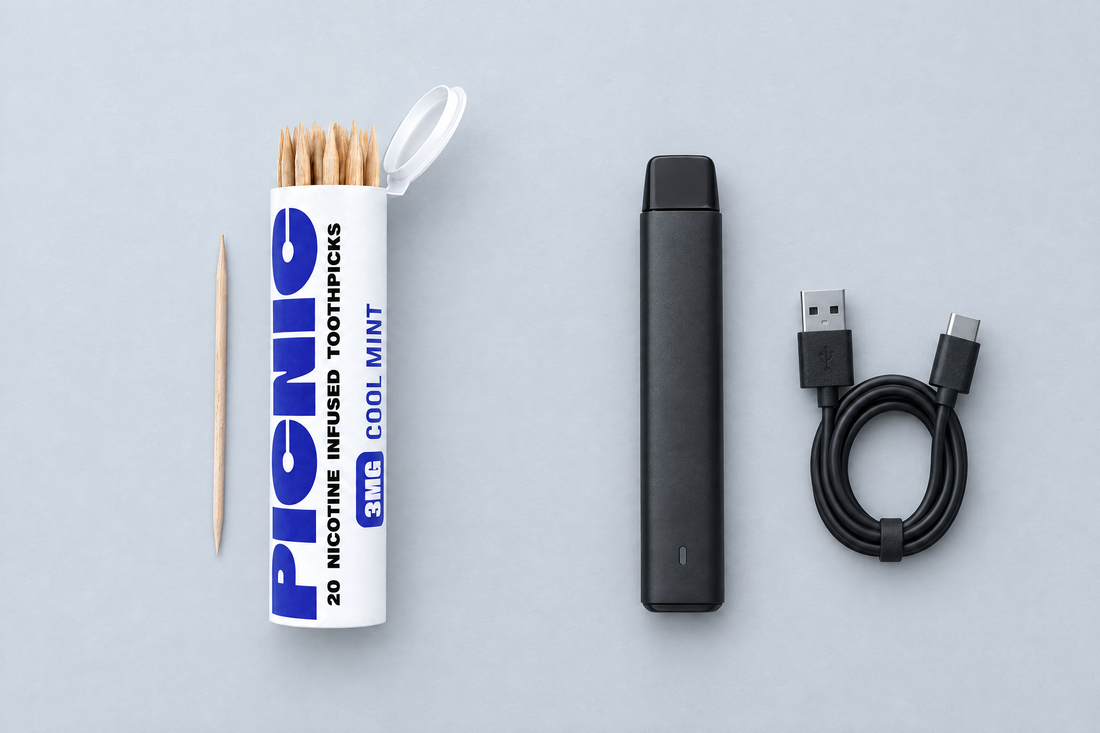 A Picnic nicotine toothpick tube next to a switched-off unbranded vape device on a desk