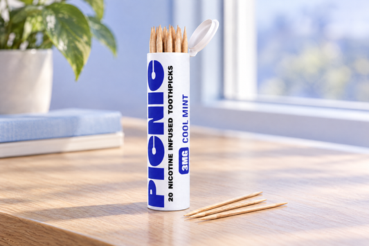 An open Picnic Cool Mint nicotine toothpick tube on a desk with three picks beside it